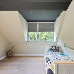 Modernes Kinderzimmer mit Dachschräge, Einzelbett, Spielzeug und großem Fenster.